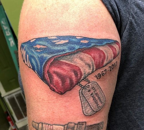 A folded American flag tattoo for the fallen