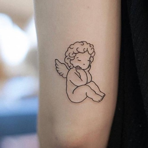 Minimalist cherub tattoo on the arm