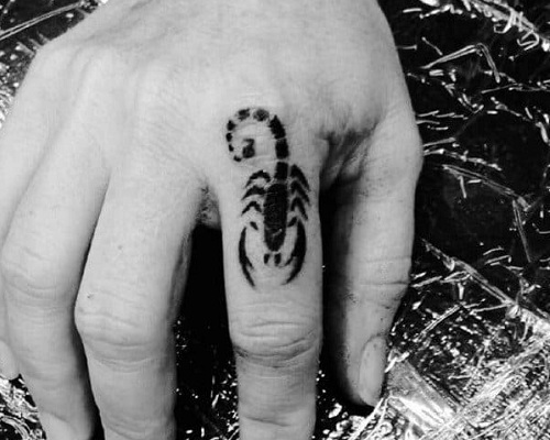Minimalist scorpion tattoo on a finger