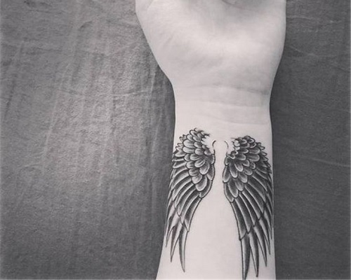Small angel wings tattoo on an arm